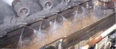 Кронштейн с передней (по потоку) стороны комбайна, с форсунками (струйными вентиляторами) с плоским факелом на стороне ленты конвейера, обращённой к пустой породе
